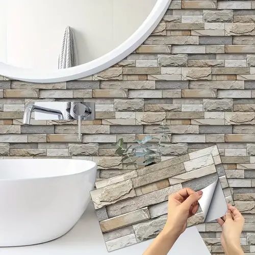 a person holding a mirror in front of a bathroom wall with stone tiles on it