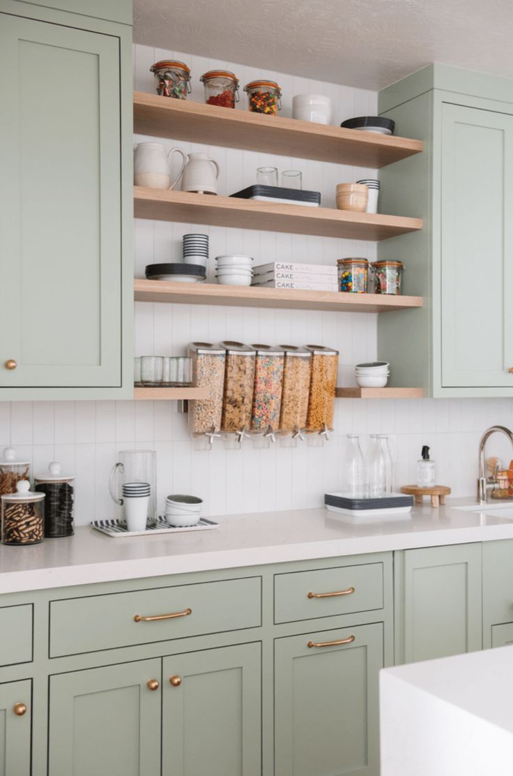 a kitchen with green cabinets and white counter tops