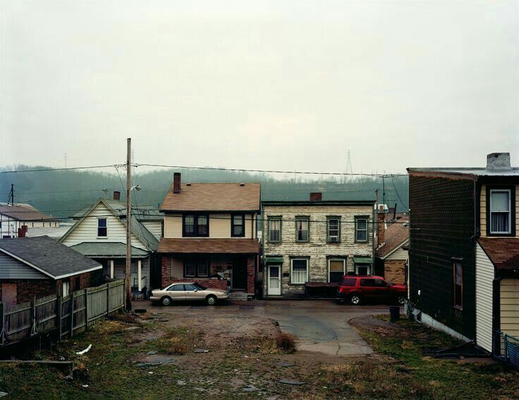 an empty street with houses and cars parked in it