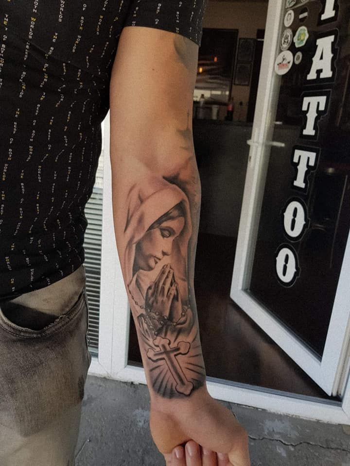 a man with a tattoo on his arm holding the hand of another person