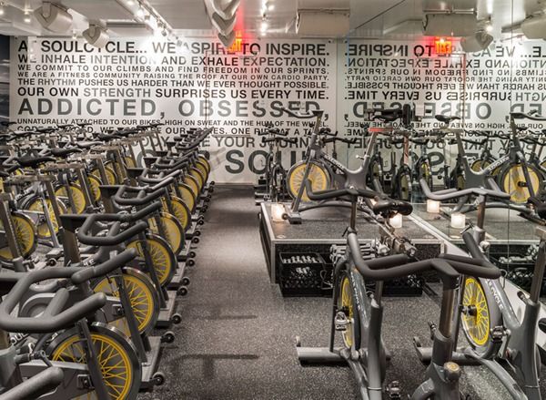 an indoor gym with rows of stationary bikes and exercise equipment in front of the wall