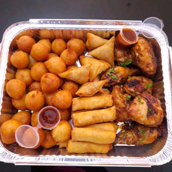 a tray filled with different types of food and dipping sauces on top of it