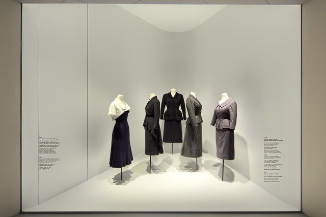 the display case is filled with mannequins dressed in black and grey outfits