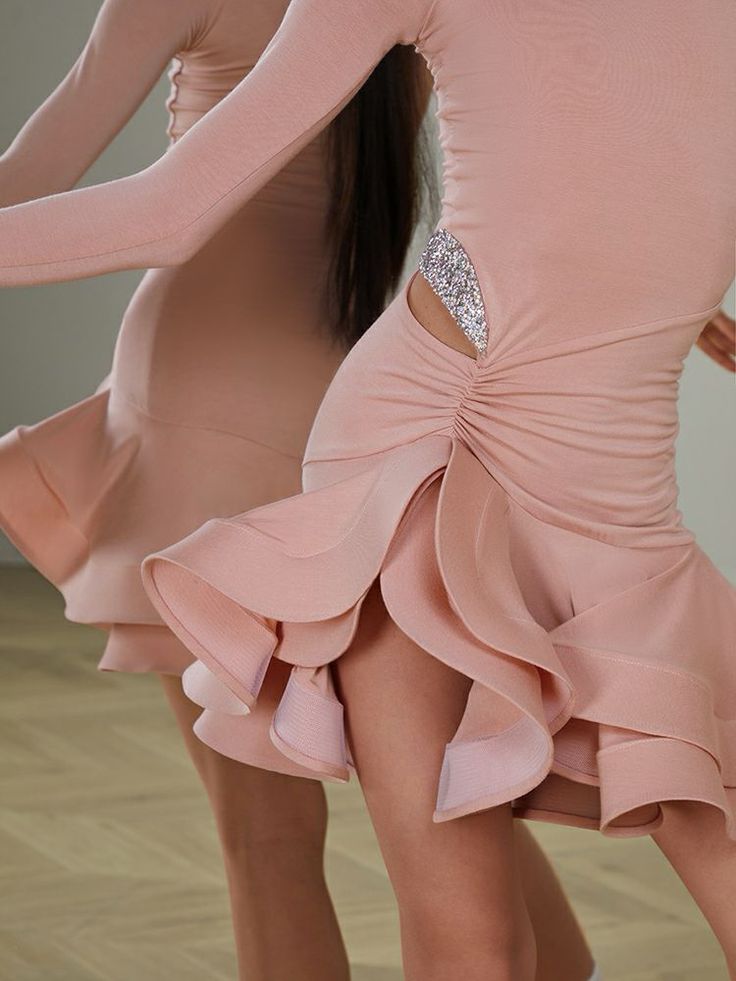 two women in pink dresses are dancing together