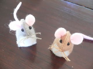 two small mice sitting on top of a wooden table