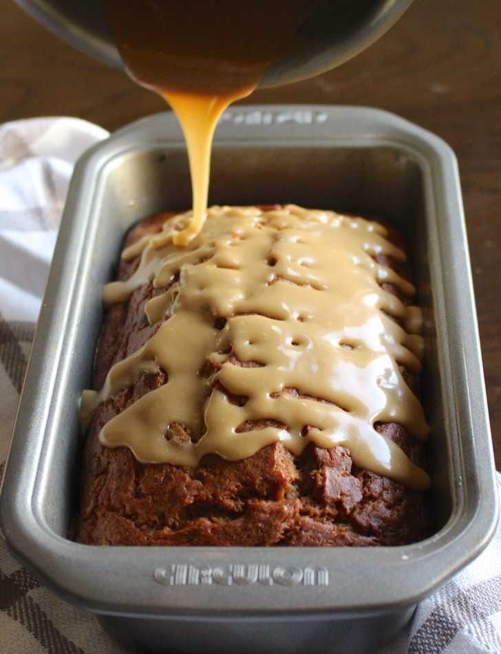 a loaf of bread with icing being drizzled over it in a pan