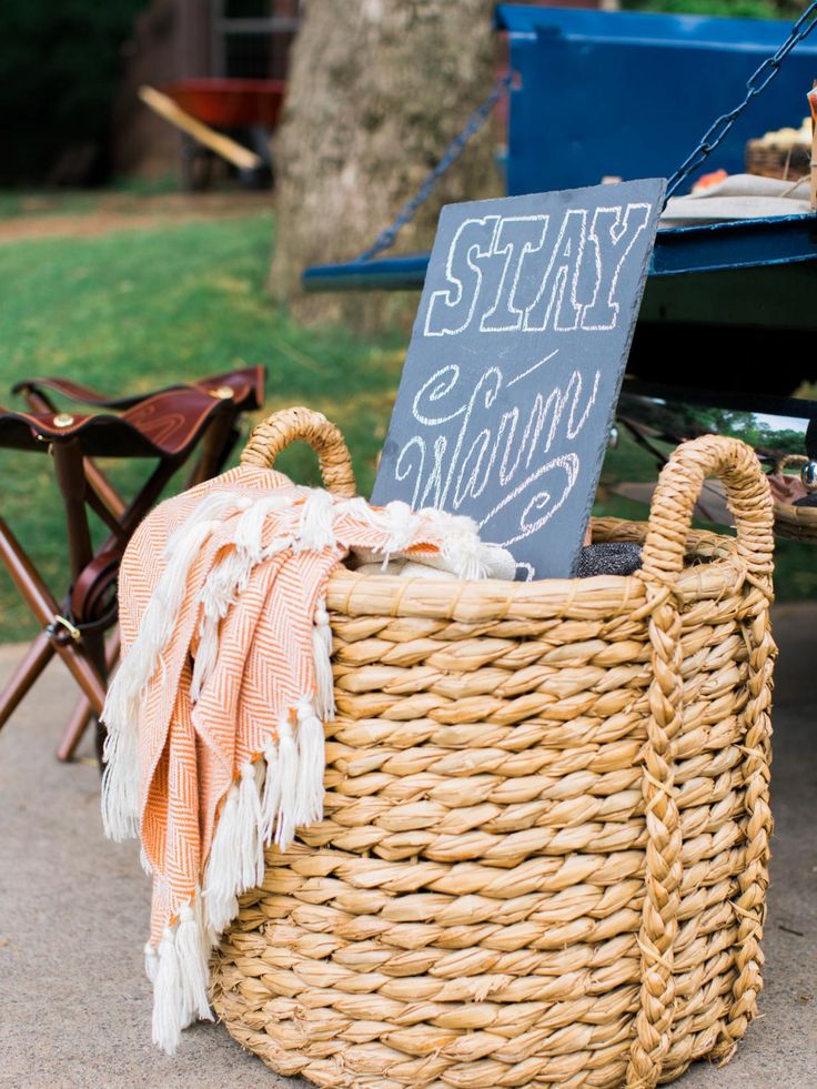 a picnic table with a sign that says stay strong and some blankets in a wicker basket