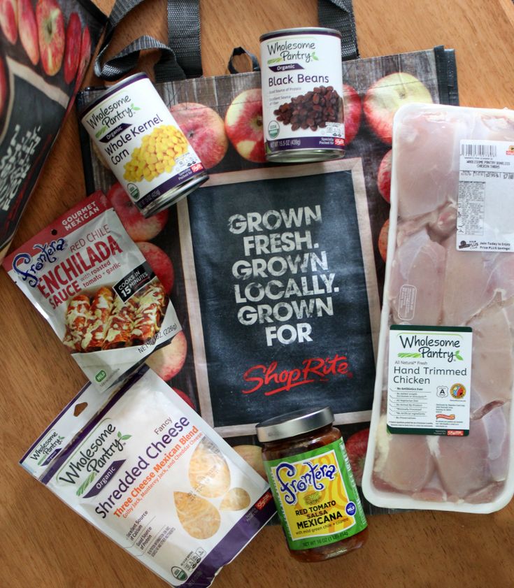 an assortment of frozen food items laid out on top of a wooden table next to a chalkboard