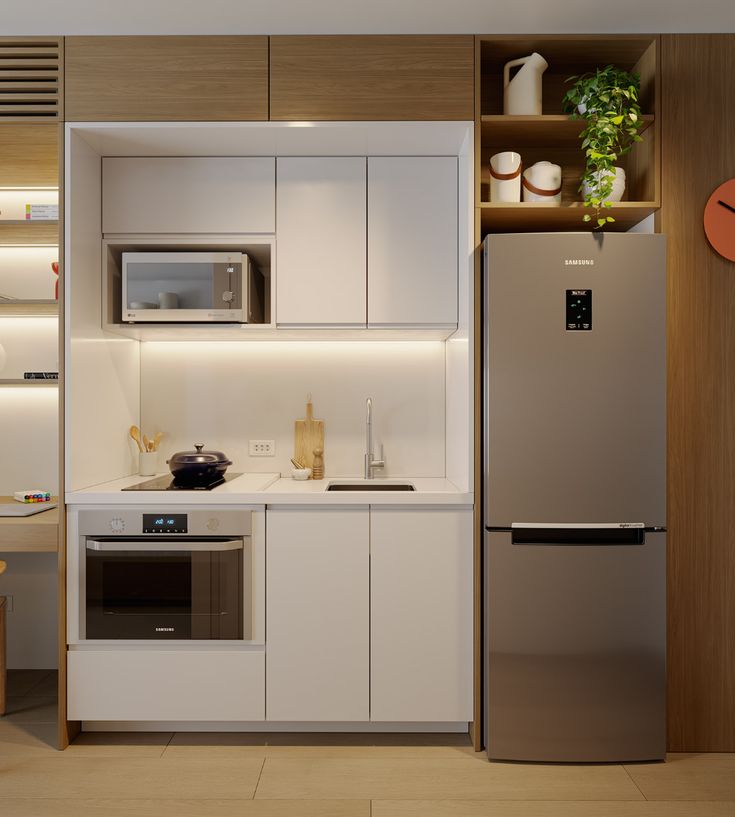 a modern kitchen with stainless steel appliances and white cupboards, including a refrigerator freezer