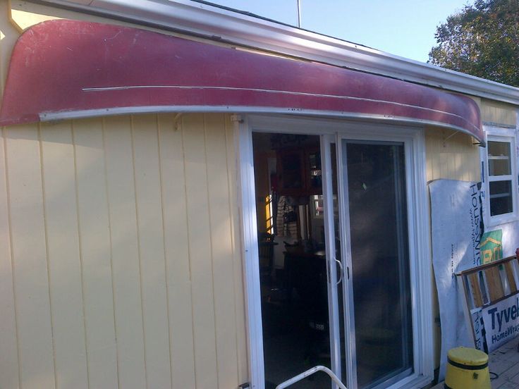 a yellow building with a red awning next to it's door and windows