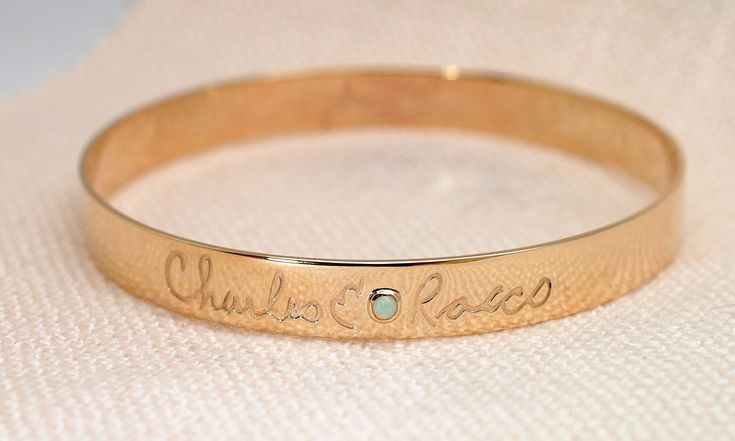 This is a solid 14k gold custom made bangle bracelet with custom writing. It is available in 14k yellow, rose and white gold. You could use handwriting or fonts, you could have writing on the outside or inside of the bracelet or both. Also there are gemstones and diamonds available to add to the bracelet. To add more birthstones https://etsy.me/31k4A1z To add more diamonds https://etsy.me/318joQF You could contact me with information you would like on the bracelet and I'll sketch it up for you. Luxury 14k Stamped Bangle Gift, 14k Gold Hallmarked Cuff Bracelet For Anniversary, Hallmarked 14k Gold Cuff Bracelet For Anniversary, 14k Gold Hallmarked Cuff Bracelet As Gift, 14k Gold Cuff Bracelet With Polished Finish Gift, 14k Gold Polished Cuff Bracelet Gift, 14k Gold Polished Finish Cuff Bracelet Gift, 14k Stamped Round Bangle For Gift, Personalized Gold Bangle Bracelet