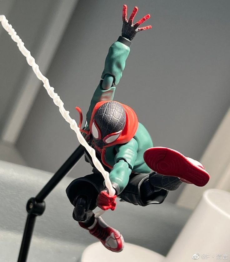 a spider - man action figure is posed with his arms and legs outstretched in the air