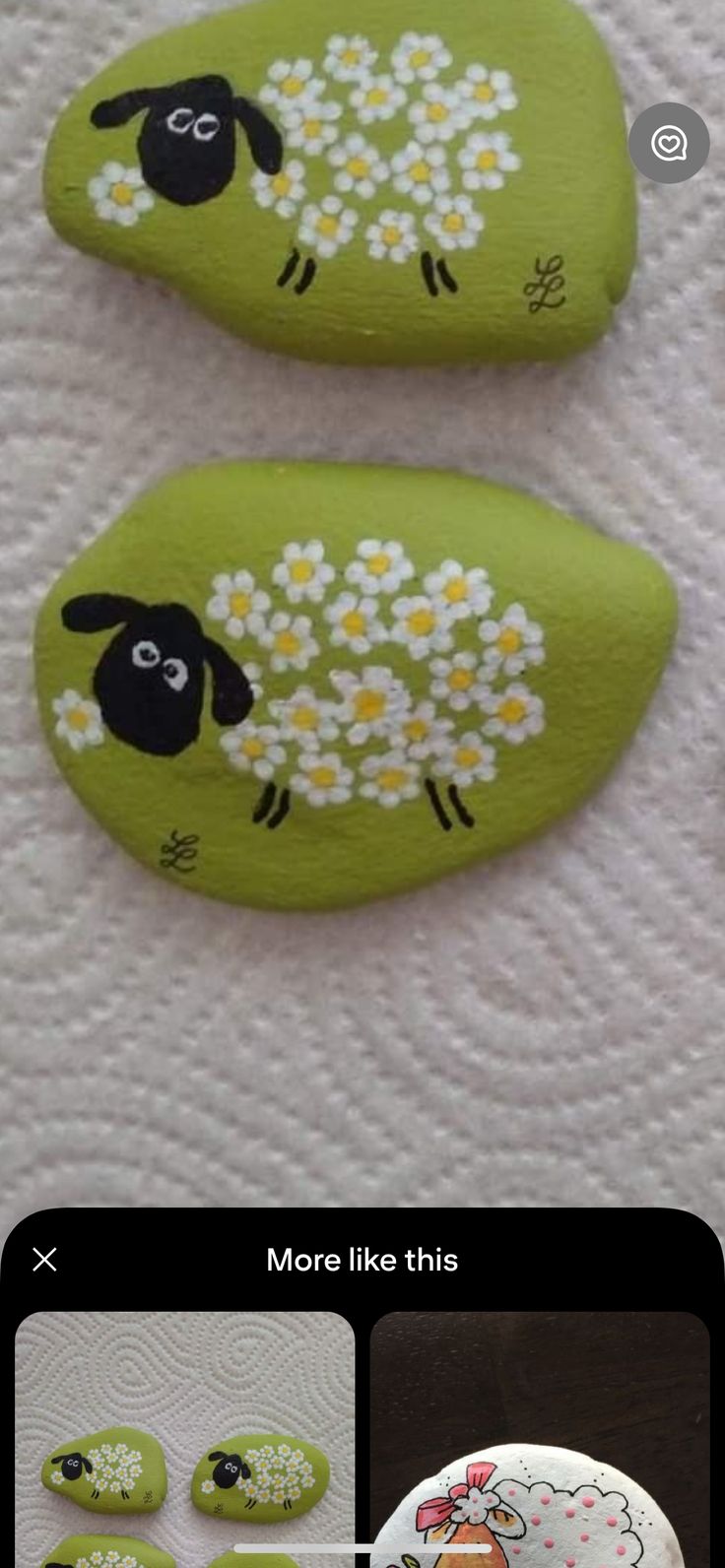 two green painted rocks with sheep and daisies on them