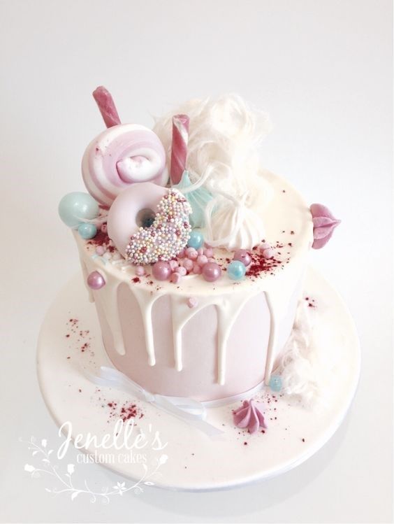 a white cake with pink and blue decorations