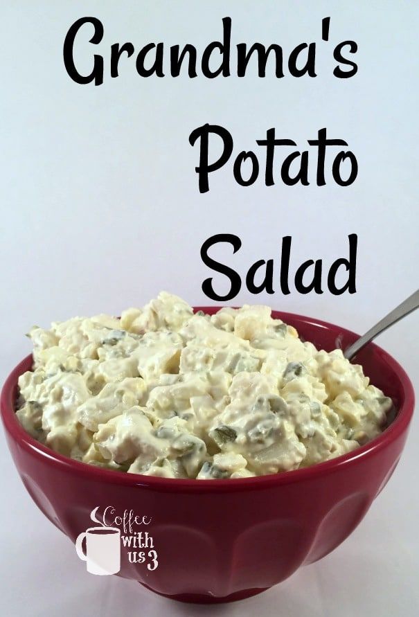 a red bowl filled with potato salad on top of a white table next to a sign that says grandma's potato salad