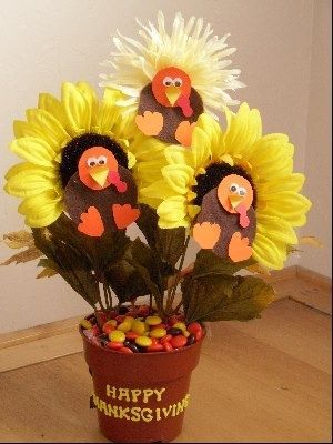 a potted plant filled with sunflowers and fake turkey heads