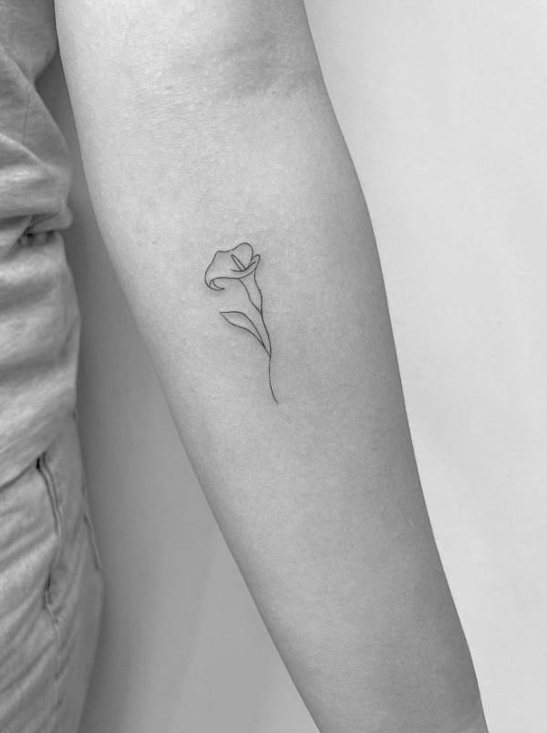 a woman's arm with a single line flower tattoo on the left inner arm