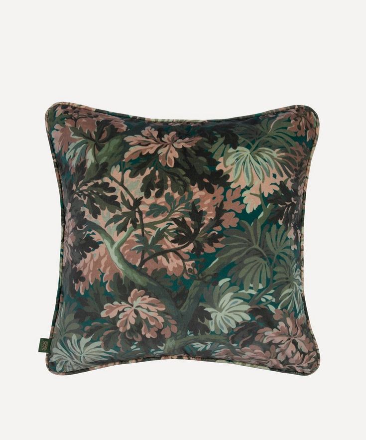 a green and pink floral pillow on a white background