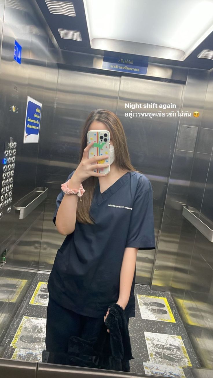 a woman taking a selfie in an elevator with her cell phone up to her face