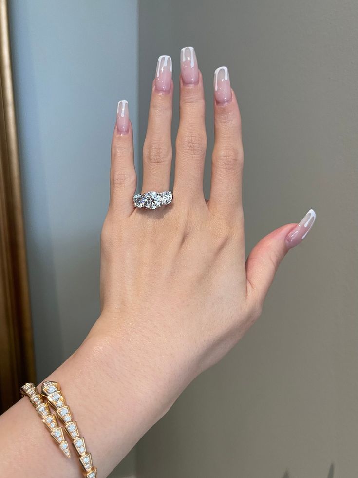 a woman's hand with two rings on her left and one ring on her right