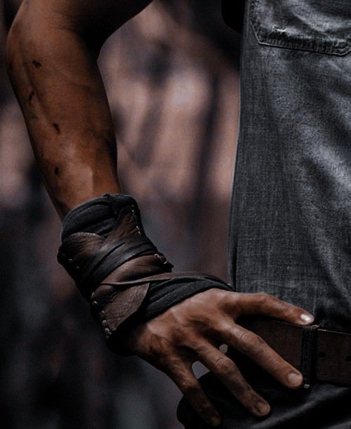 a man with his hand wrapped around the wrist and wearing leather bracelets on it