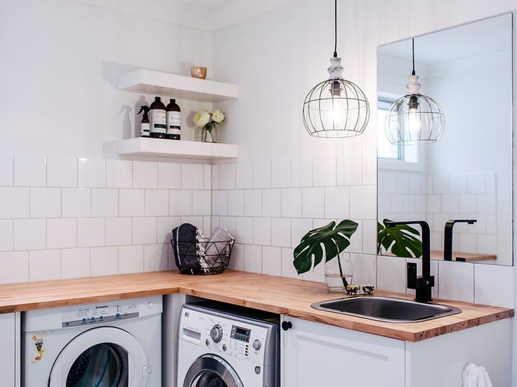 a washer and dryer sitting in a kitchen next to a counter with a potted plant