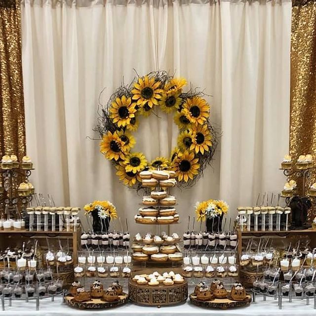 the dessert table has sunflowers and cupcakes on it