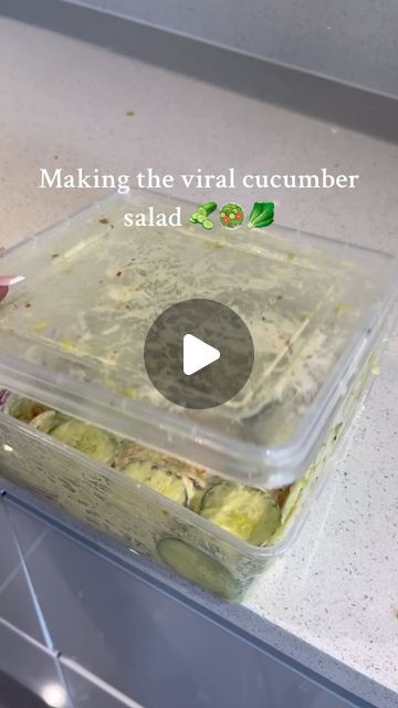 someone is making a meal in a plastic container on the kitchen counter with text reading making the virtual cucumber salad