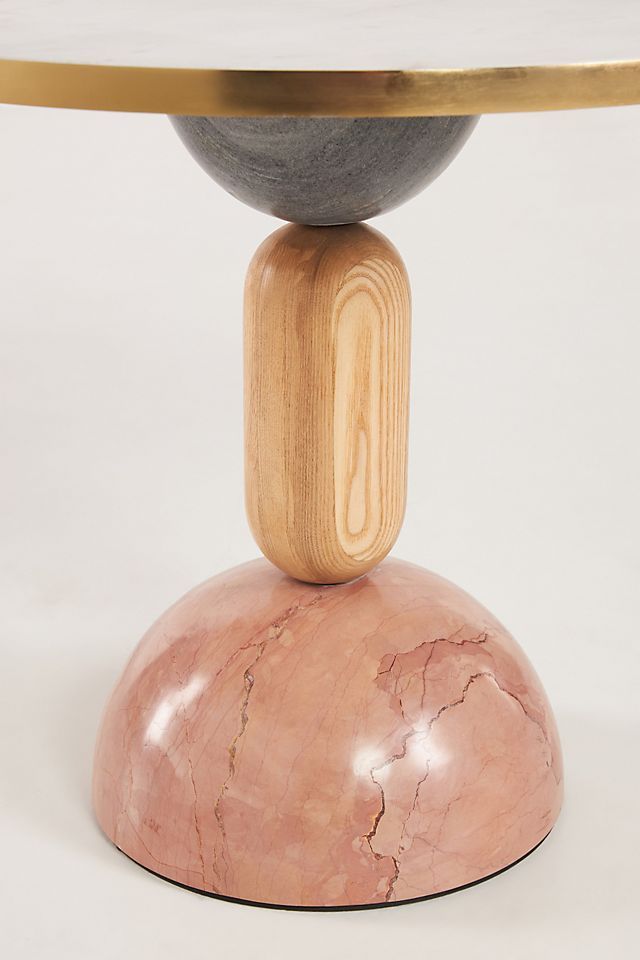 a round table with a wooden base and two marble balls on it's top