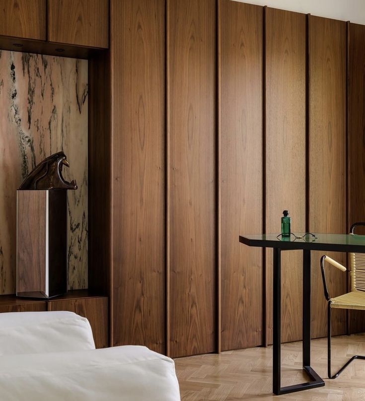 a bedroom with wood paneling and a desk