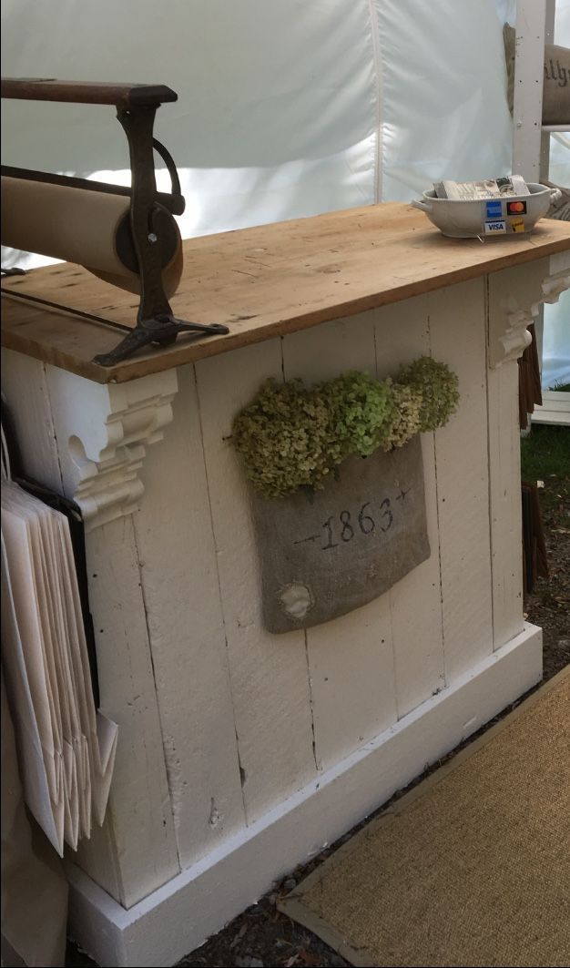 an outdoor kitchen with a potted plant on the counter and a white tent behind it