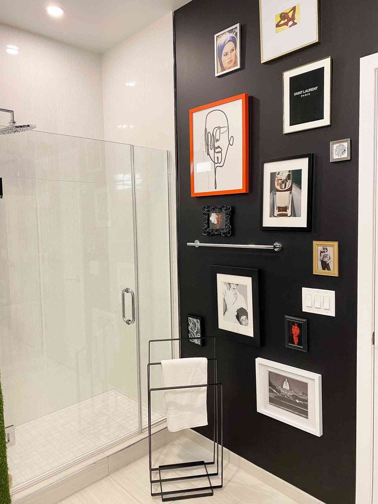 a bathroom with black walls and pictures on the wall