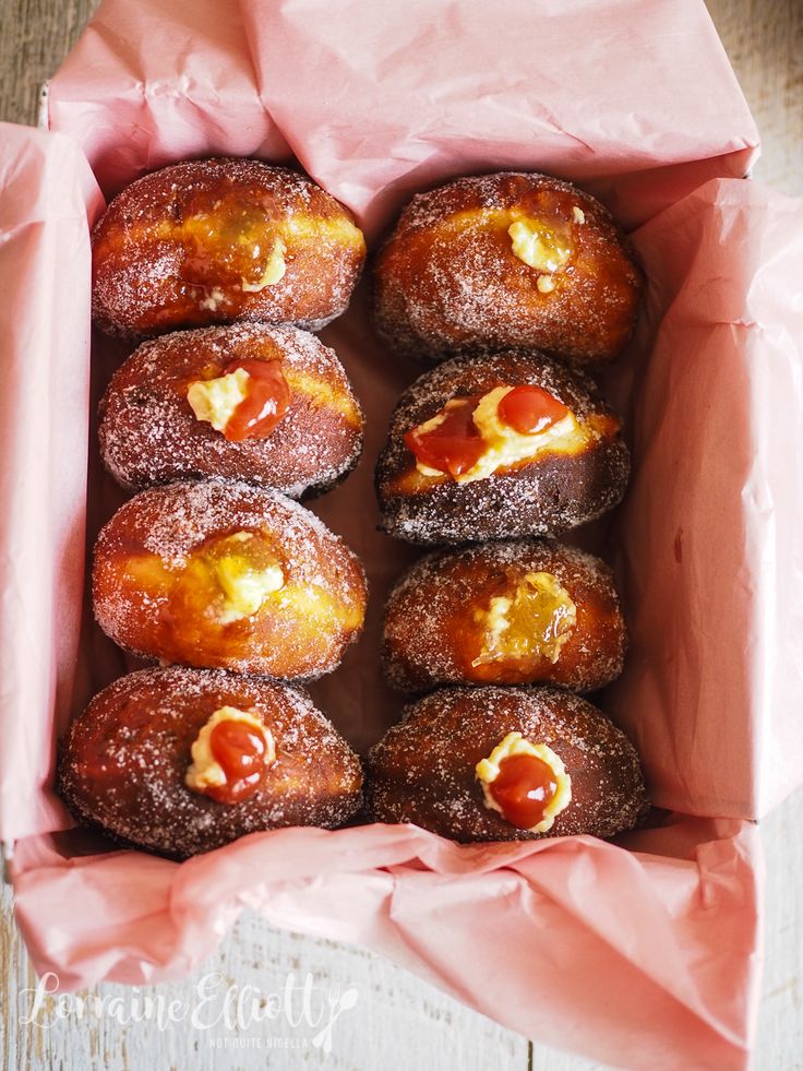 a box filled with doughnuts covered in jelly and cheese on top of each other