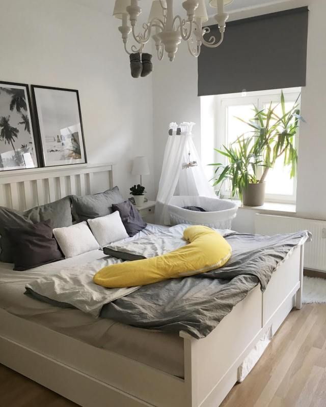 a bedroom with a bed, chandelier and pictures on the wall above it