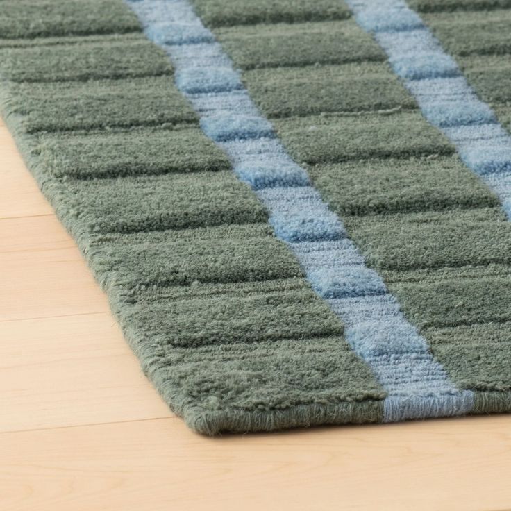 a blue and green rug on a wooden floor