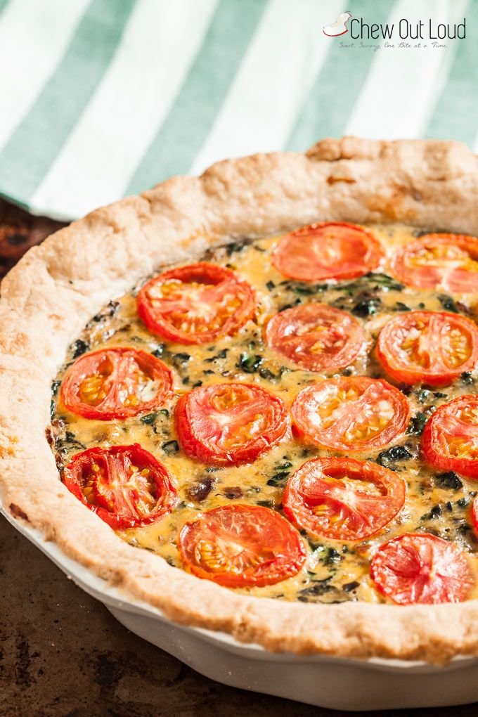 a pizza with tomatoes and spinach on it