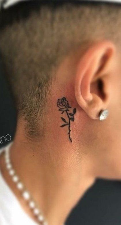 a man with a small rose tattoo on his left side behind the ear and behind the ear