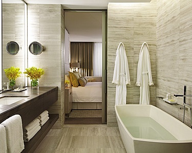 a bathroom with a bathtub, sink and towels hanging on the wall next to it