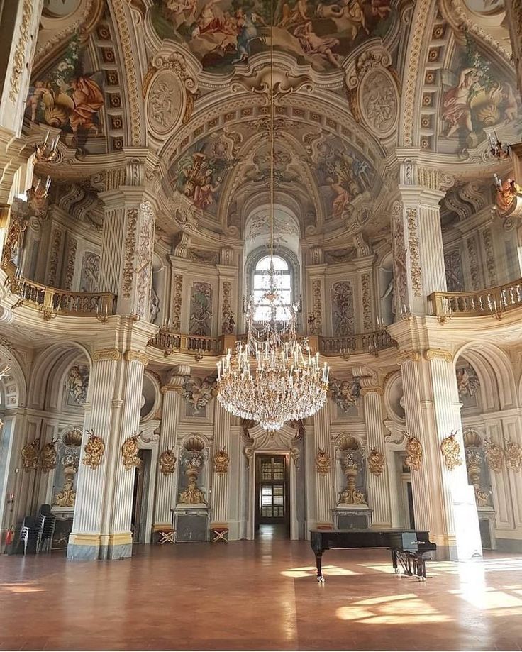 an ornate room with chandeliers and paintings on the walls