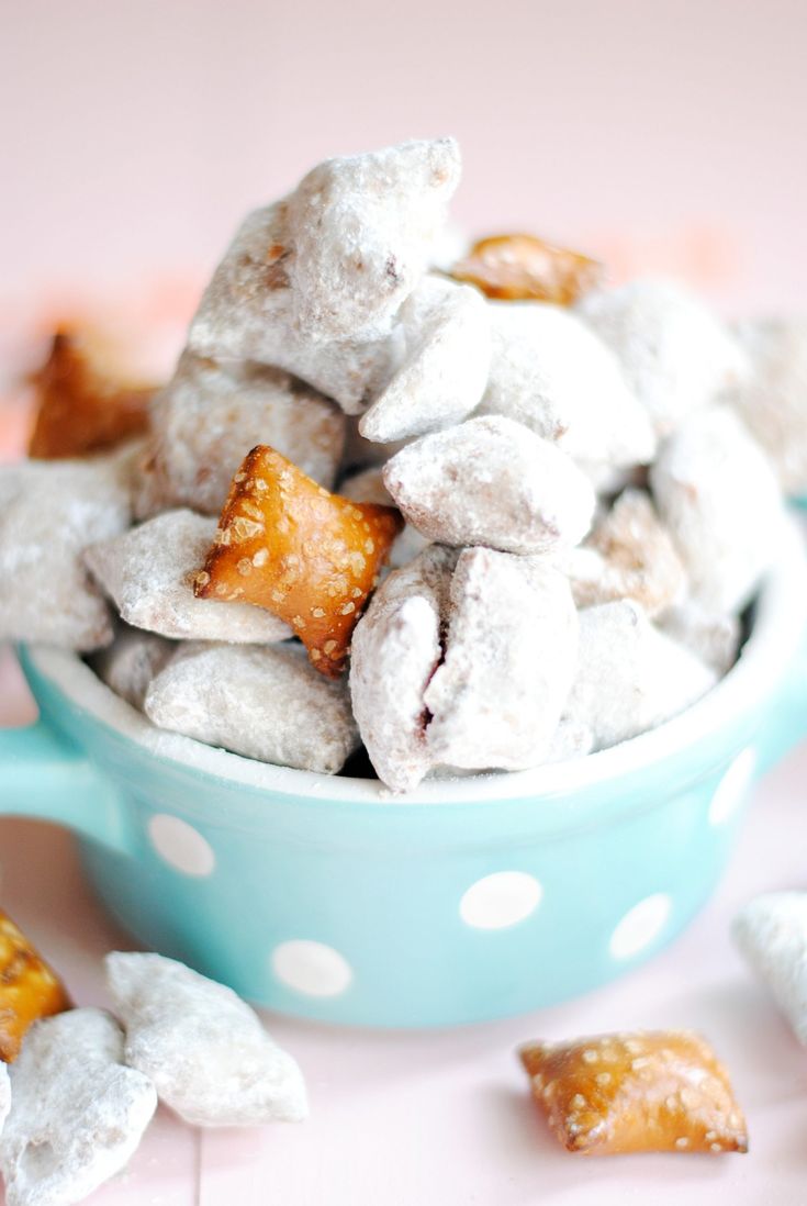 a blue bowl filled with powdered sugar coated treats