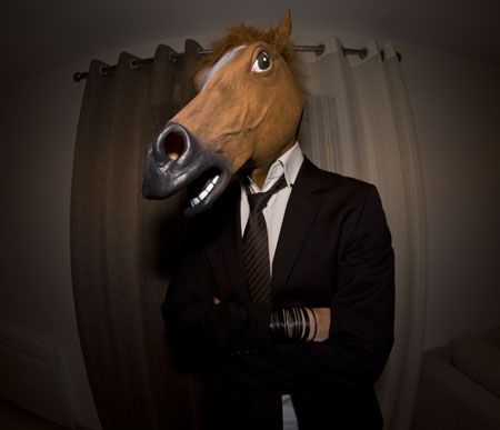 a man in a suit with a horse mask on