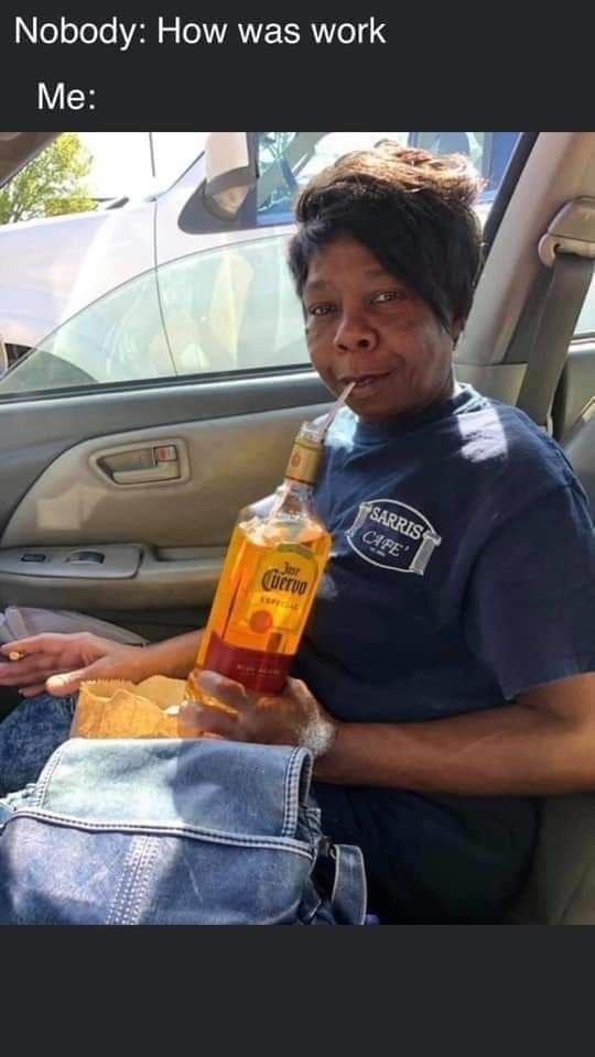 a woman sitting in the back seat of a car holding a bottle