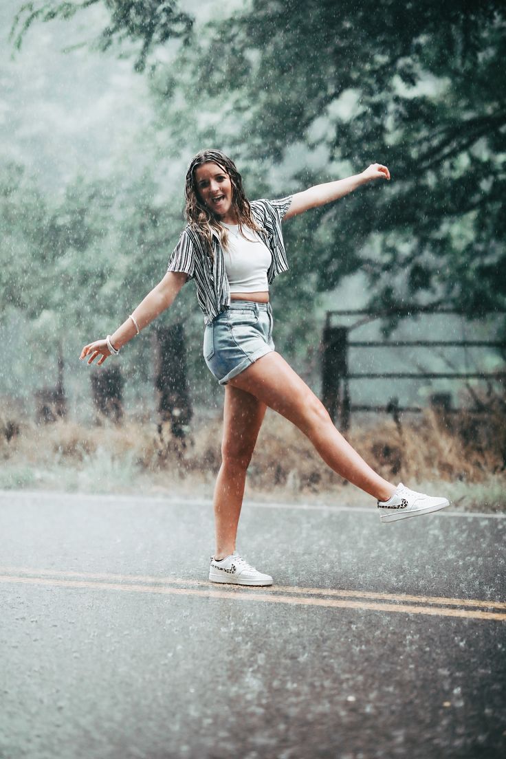 a young woman is dancing in the rain