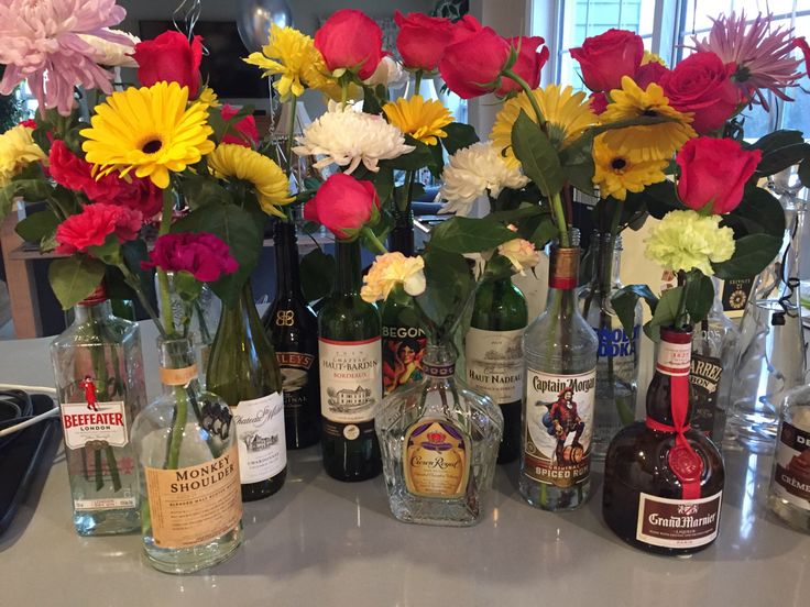 several bottles and vases filled with flowers on a counter