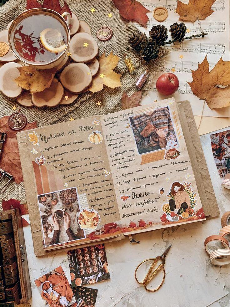 an open scrapbook surrounded by autumn leaves and other things to make it look like fall