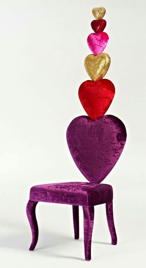 a purple chair with three hearts on top of it and a gold heart hanging from the back