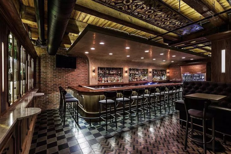 a bar with black and white checkered flooring in the middle of a room