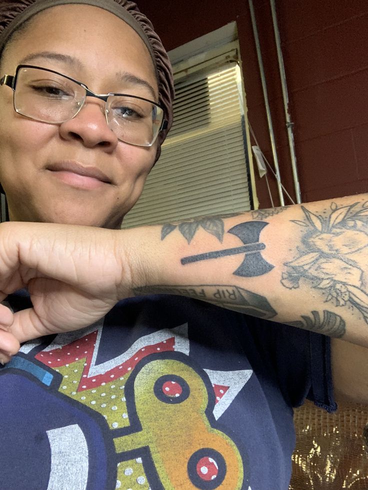 a woman with glasses and tattoos on her arm