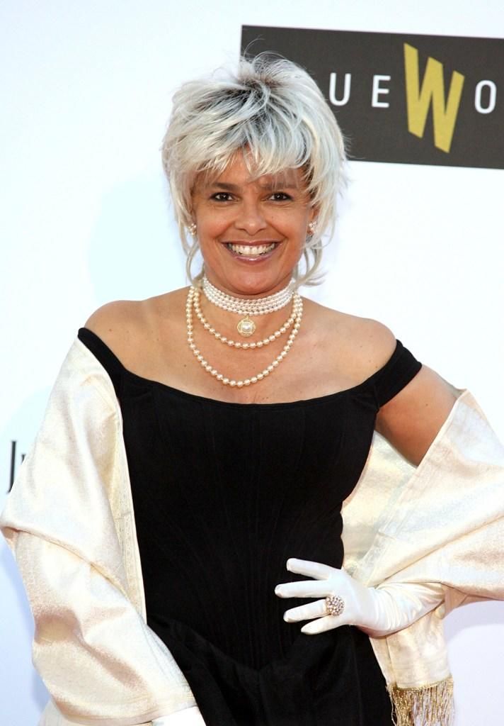 an older woman wearing pearls and gloves poses for the camera