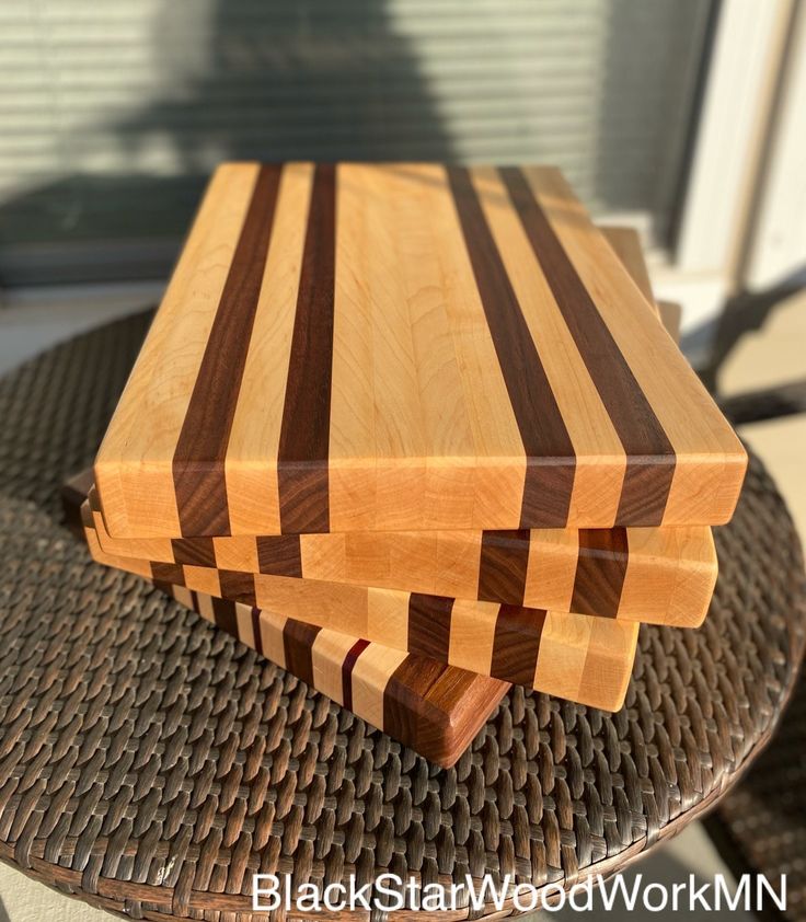 a wooden cutting board sitting on top of a metal table next to a glass door